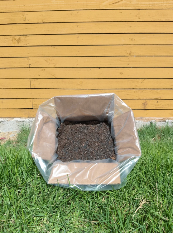Caja abierta Compostcat mostrando textura de compost maduro